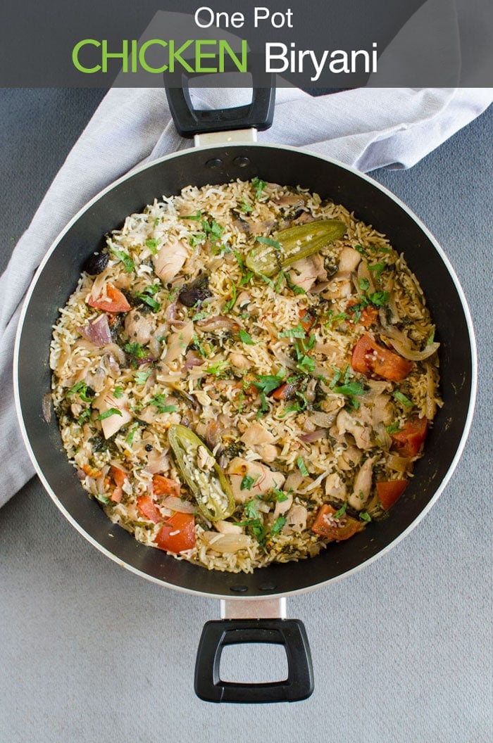 One pot easy chicken biryani in a large pot with a napkin in the background. Image has text overlay that reads 'One Pot Chicken Biryani'