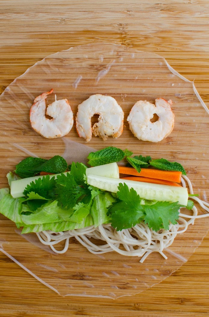 rice paper layerd with cooked shrimp, noodles and veggies for making Vietnamese healthy spring rolls.