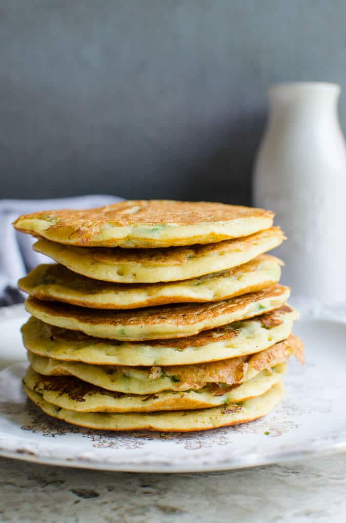 Stack of mung bean pancakes on a ceramic dinner plate.