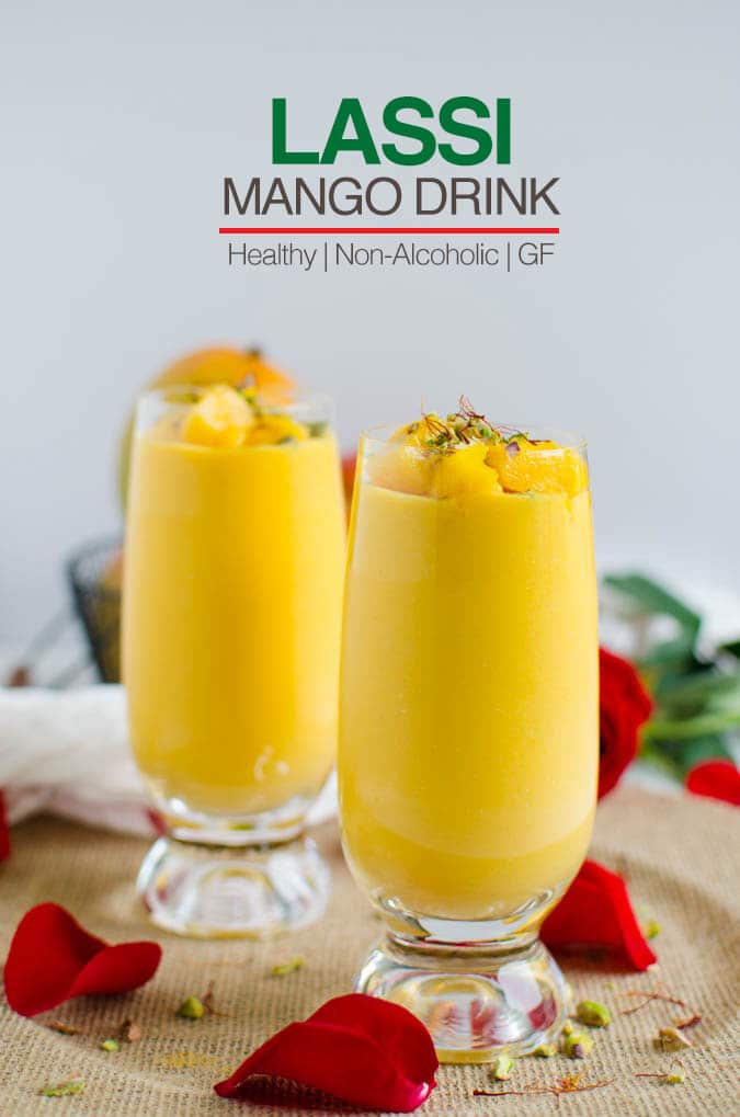 Healthy mango lassi in serving glasses, garnished with chopped pistachios and saffron threads.