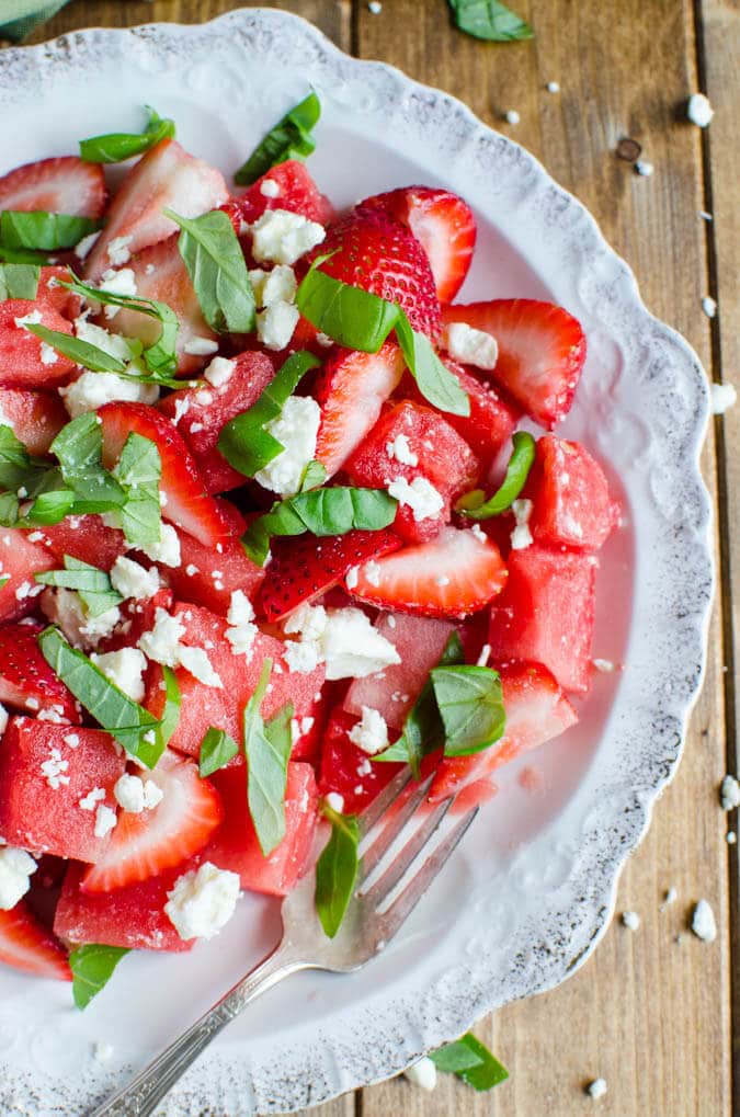 Only 4 ingredients: this watermelon strawberry feta and basil salad is perfect to enjoy seasonal fresh watermelons and strawberries. It is healthy, full of nutrients and gluten free | watchwhatueat.com
