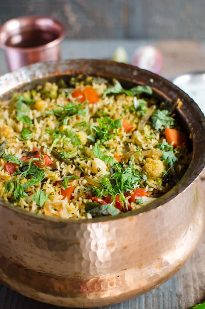 Easy vegetable biryani in a cooking pot, garnished with fresh cilantro and is ready to serve.