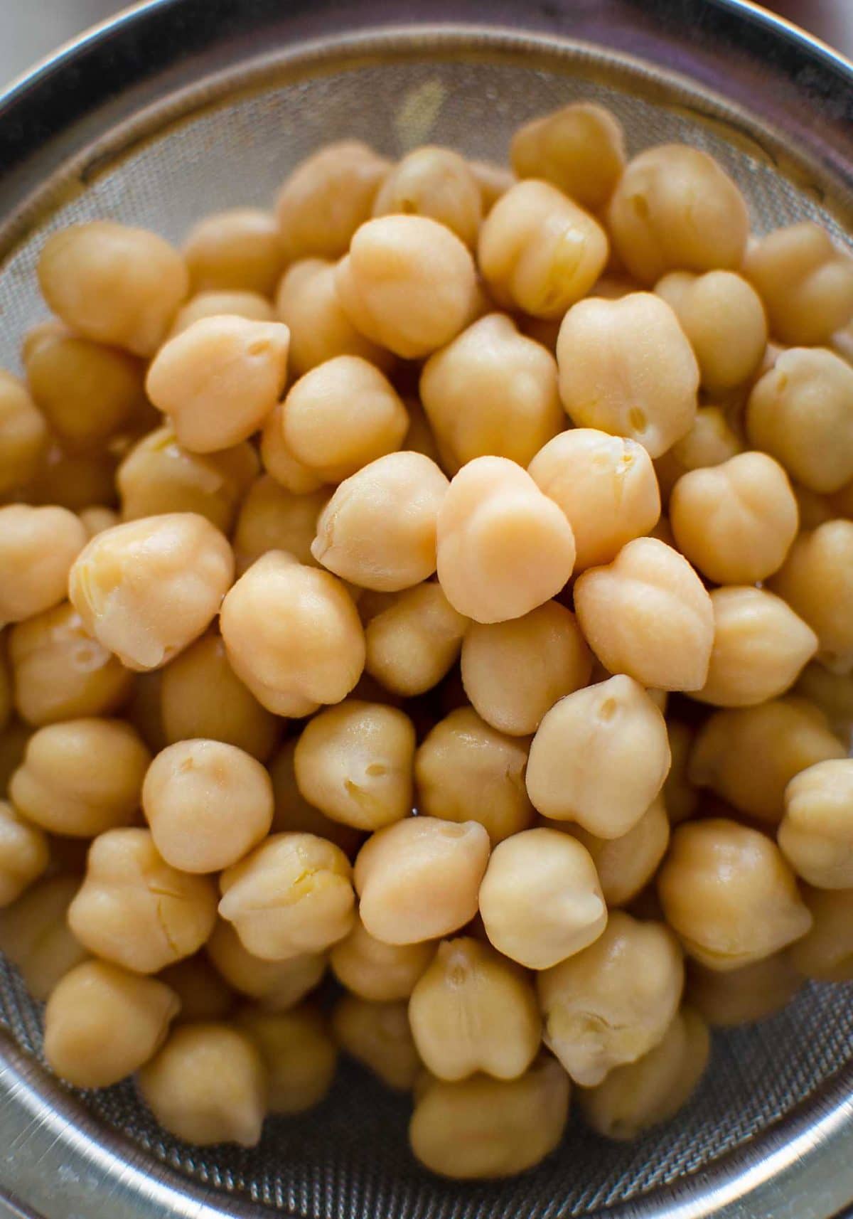 Cooked chickpeas in a strainer.