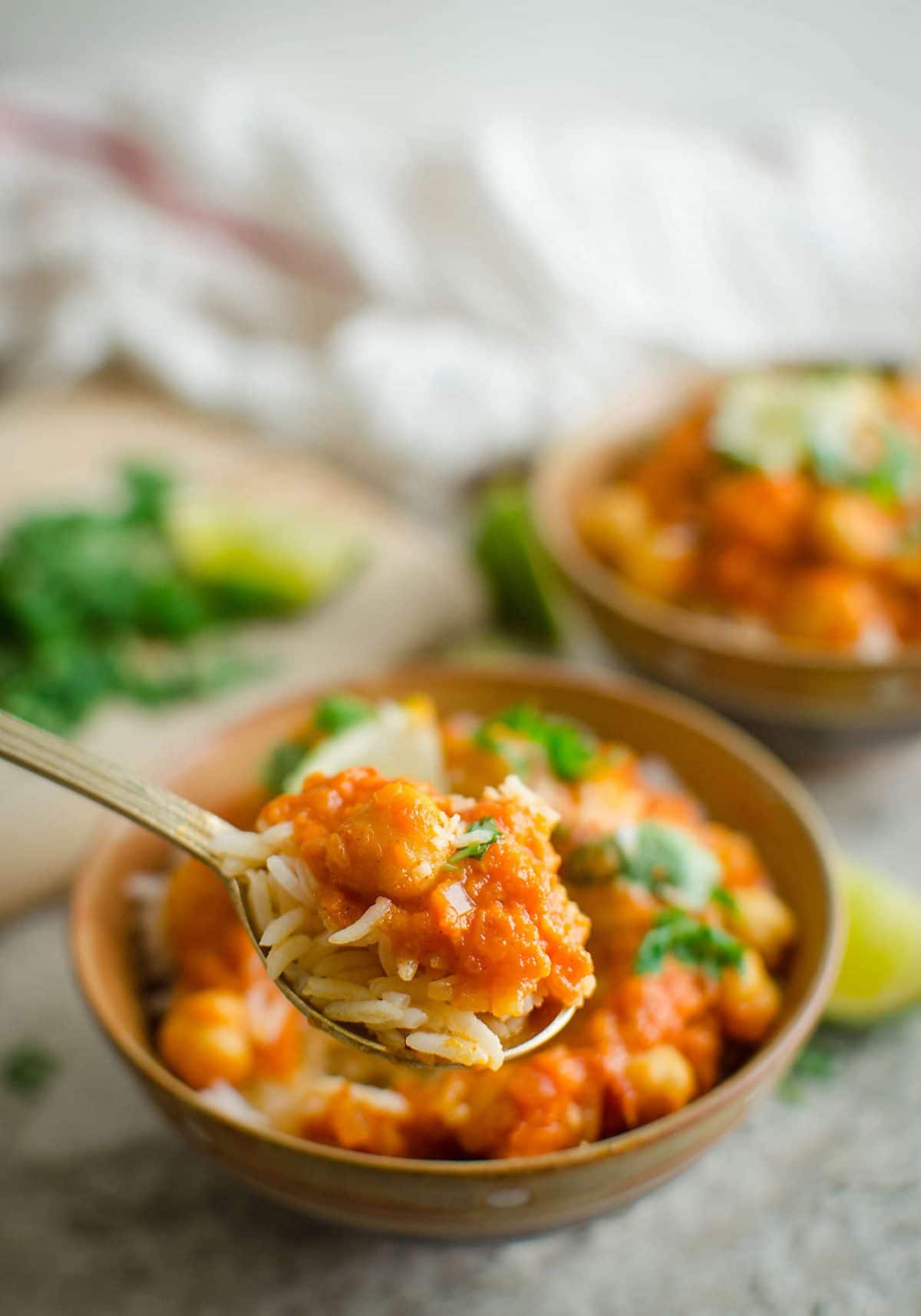 Collage image of coconut chickpea curry in a serving bowl with metal spoon. Image has text overlay that read 'Healthy Coconut Chickpea Curry'.