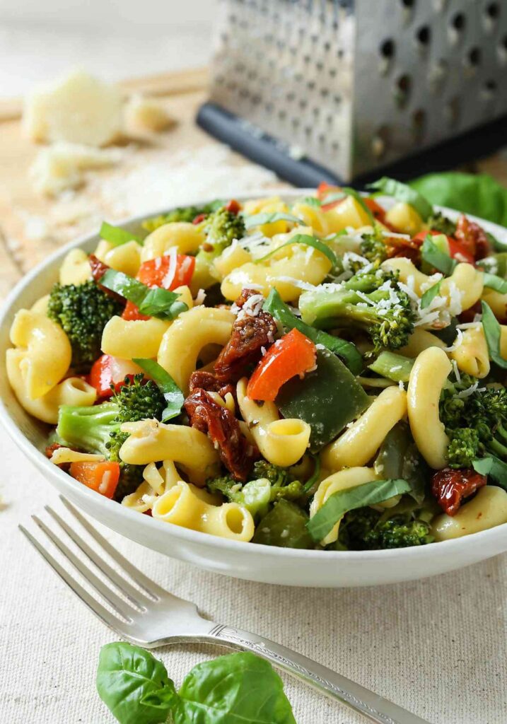 stir fry healthy veggie and pasta salad in a serving container. 