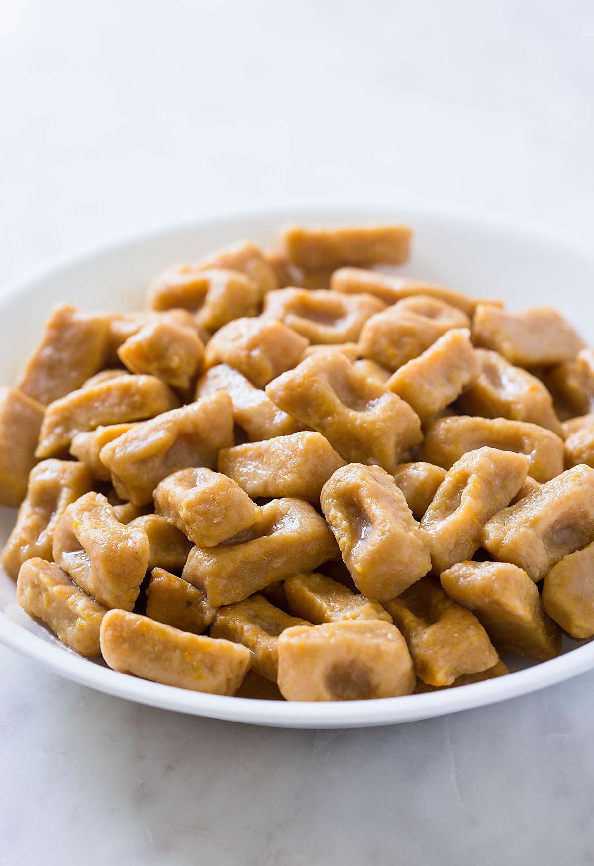 Fully cooked homemade sweet potato gnocchi in a large bowl.