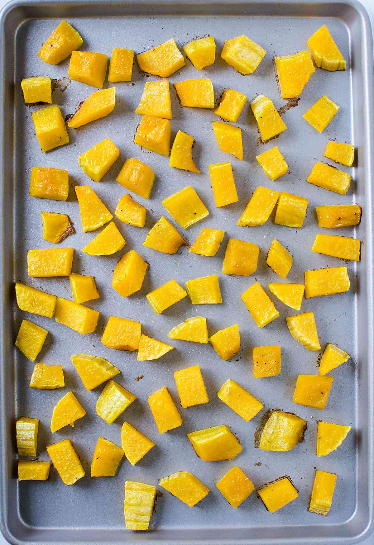 butternut squash pieces in a baking sheet after baking is over.