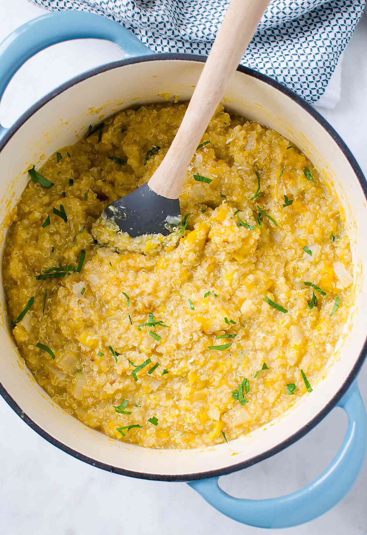 butternut squash and quinoa risotto in a dutch oven with mixing spatula.