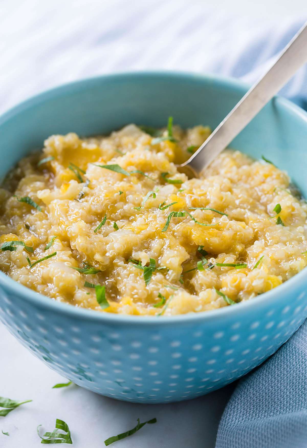 roasted healthy butternut squash quinoa risotto in a serving bowl with serving spoon.