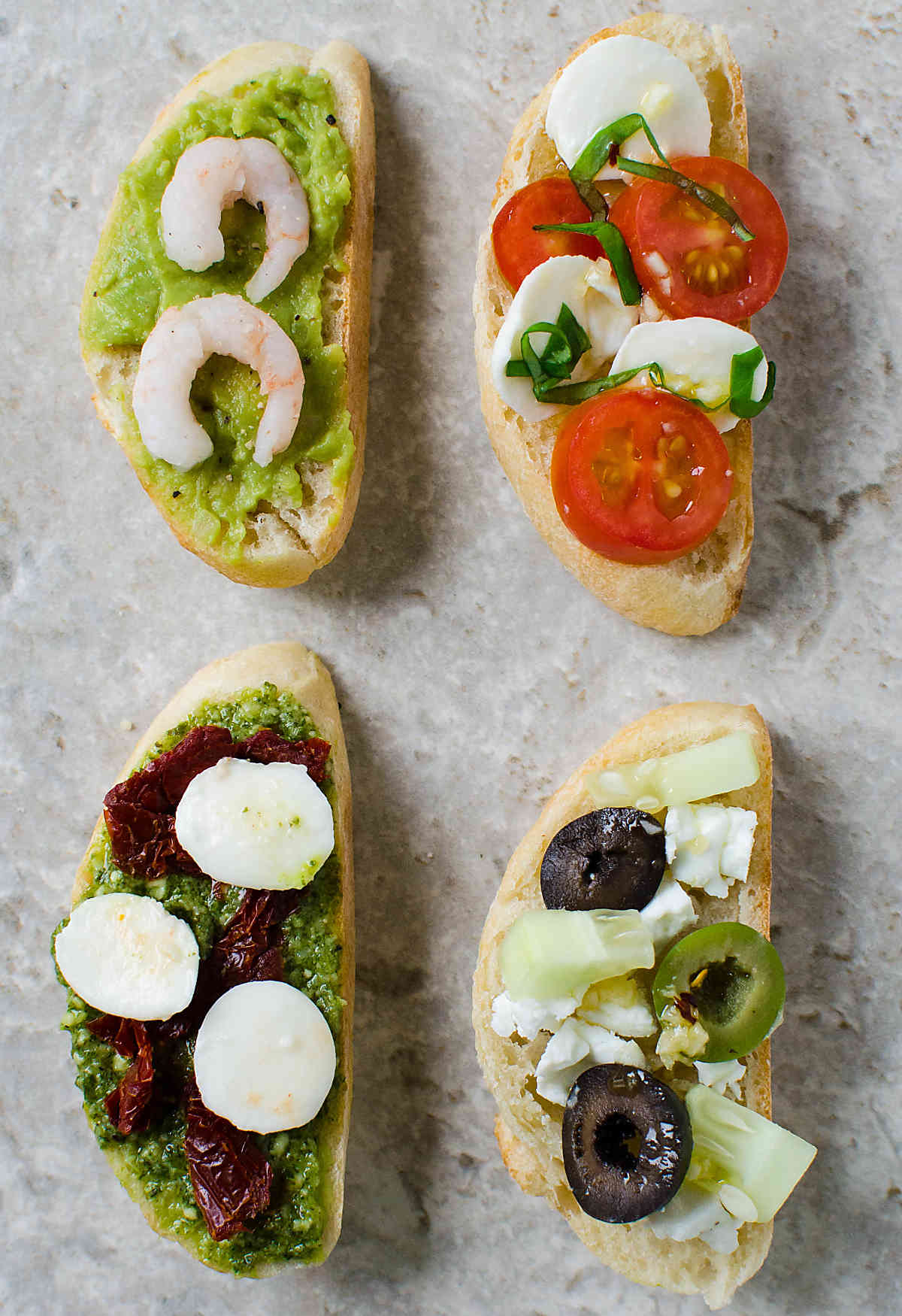 4 types of prepared crostini on a flat surface.