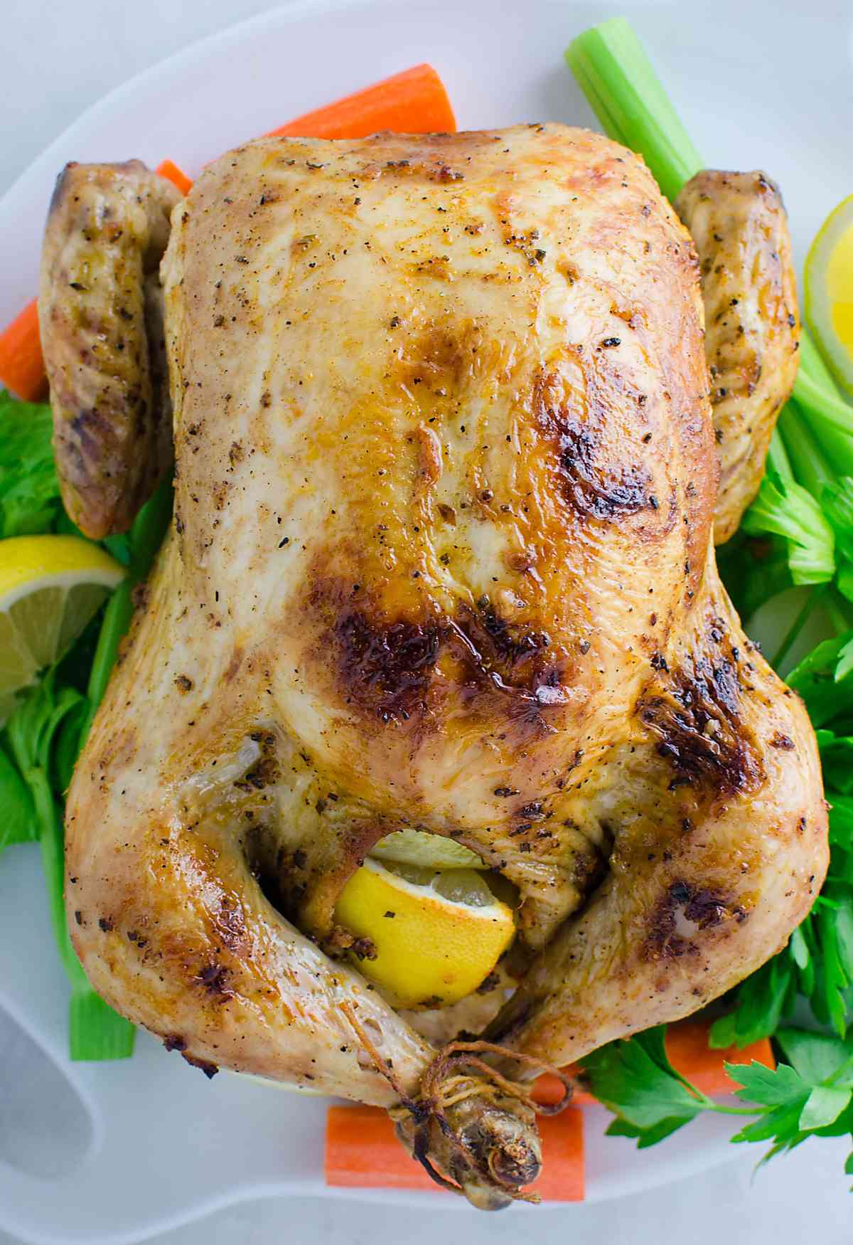 Herb roasted whole chicken on a serving platter. 