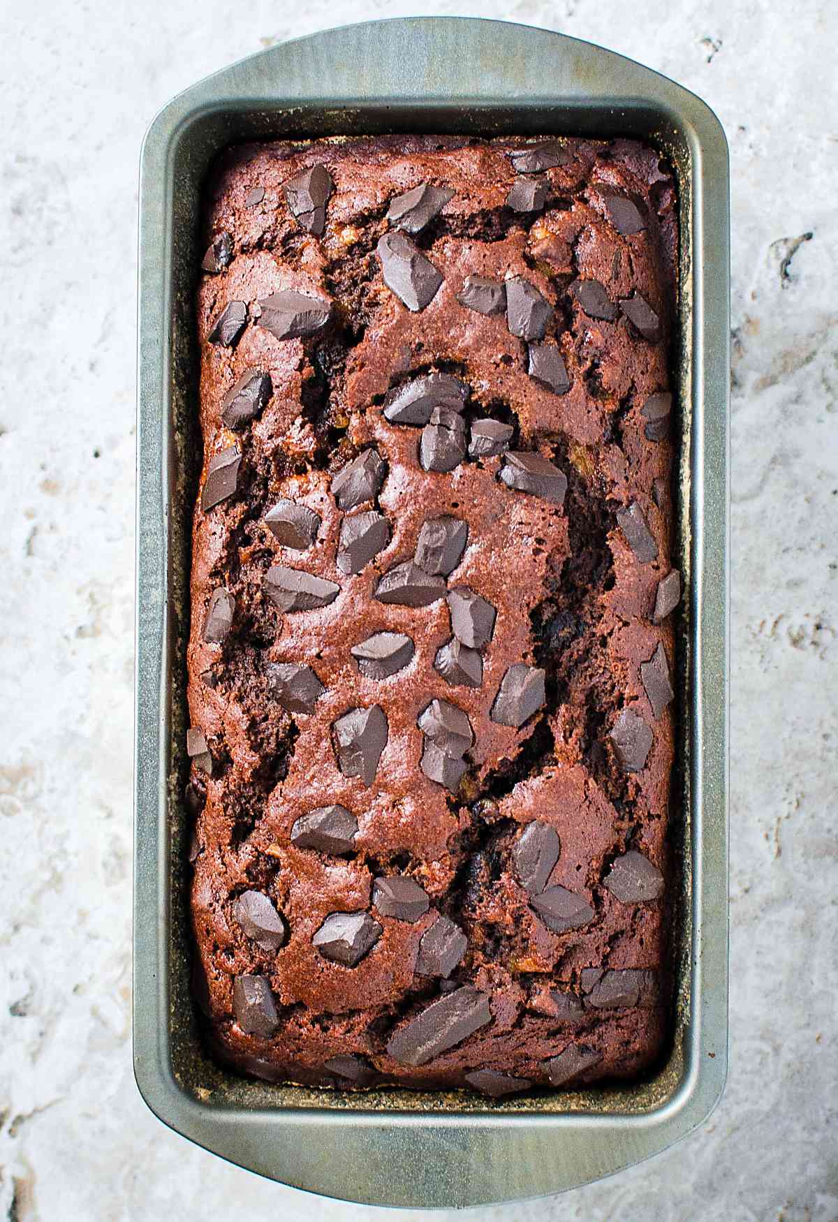 Healthy chocolate oatmeal banana bread in a metal bread loaf pan after baking