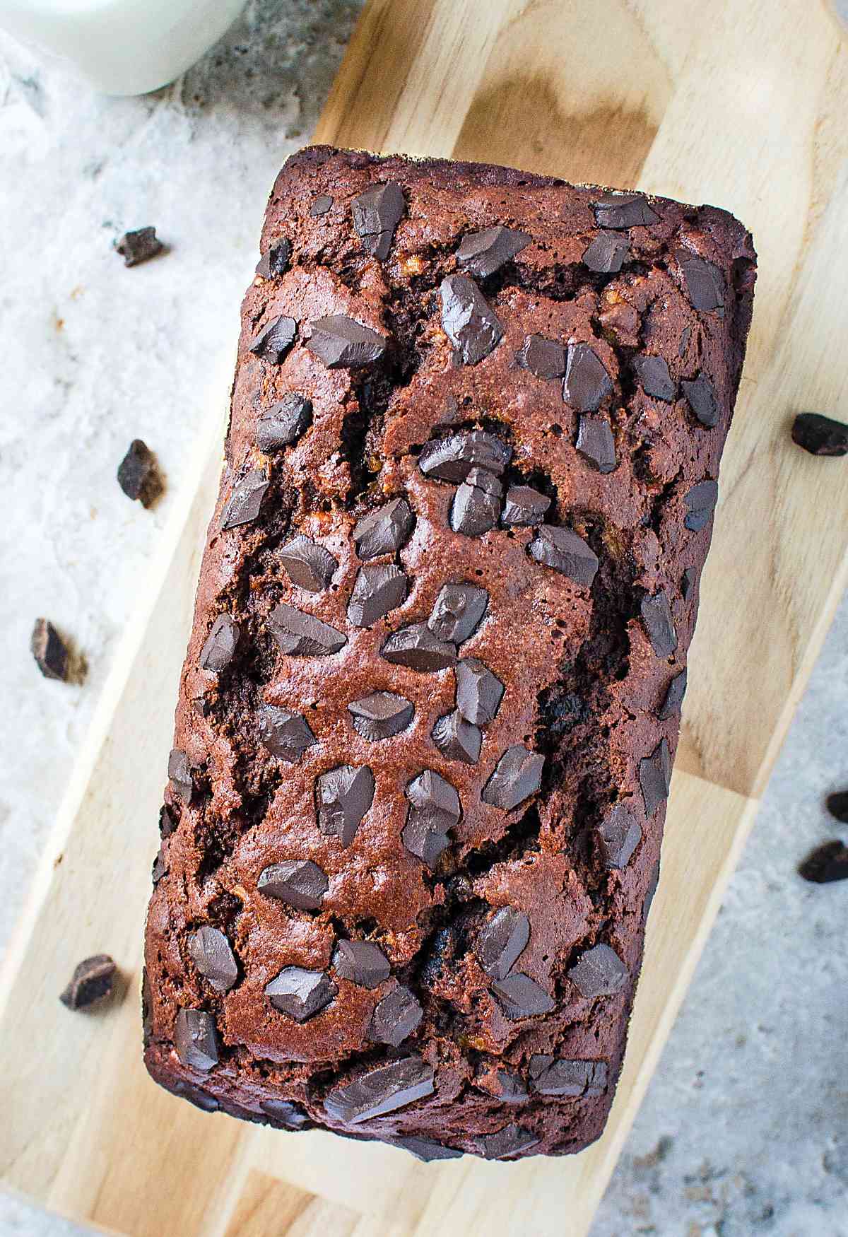 Healthy chocolate oatmeal banana bread loaf on wooden cutting board.