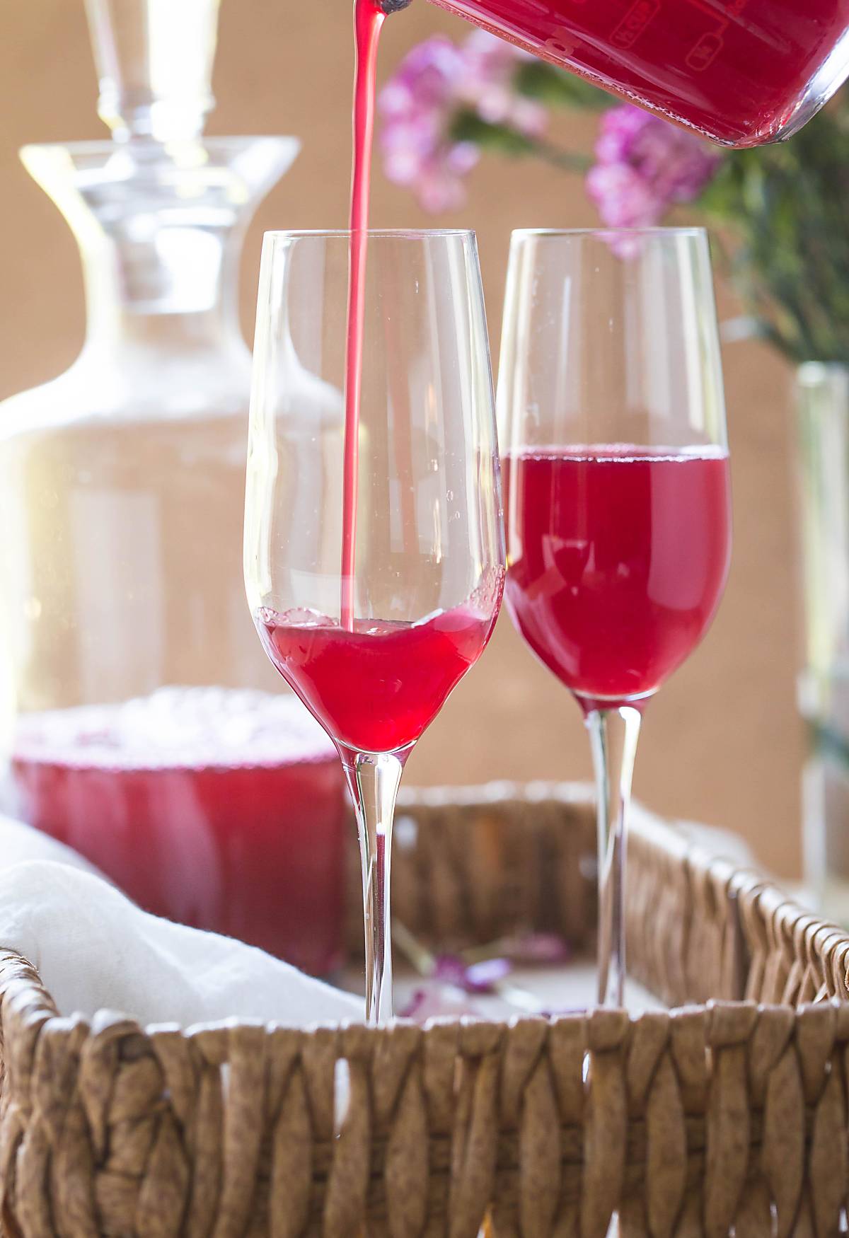 Image with fresh Cranberry drink while pouring in champagne flute.