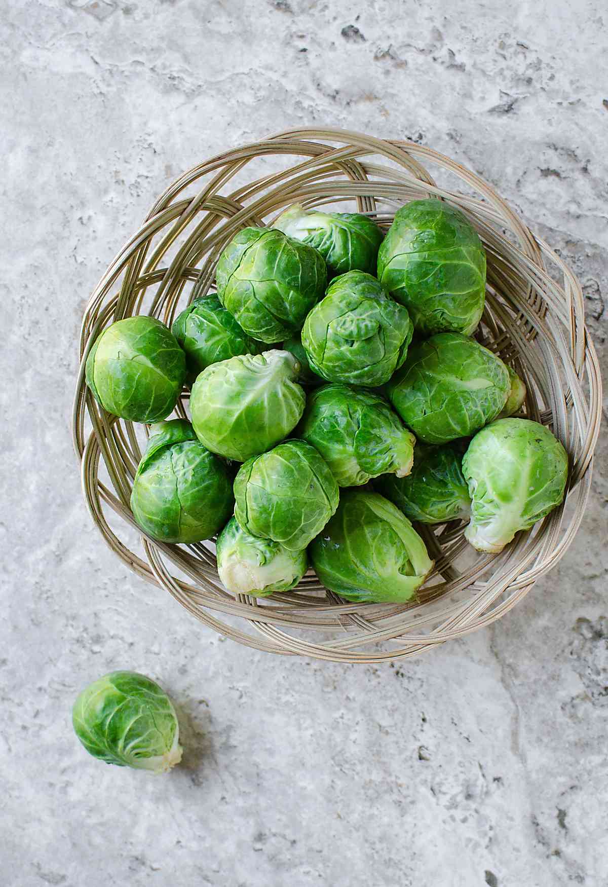 Fresh raw whole brussels sprouts in a basket.