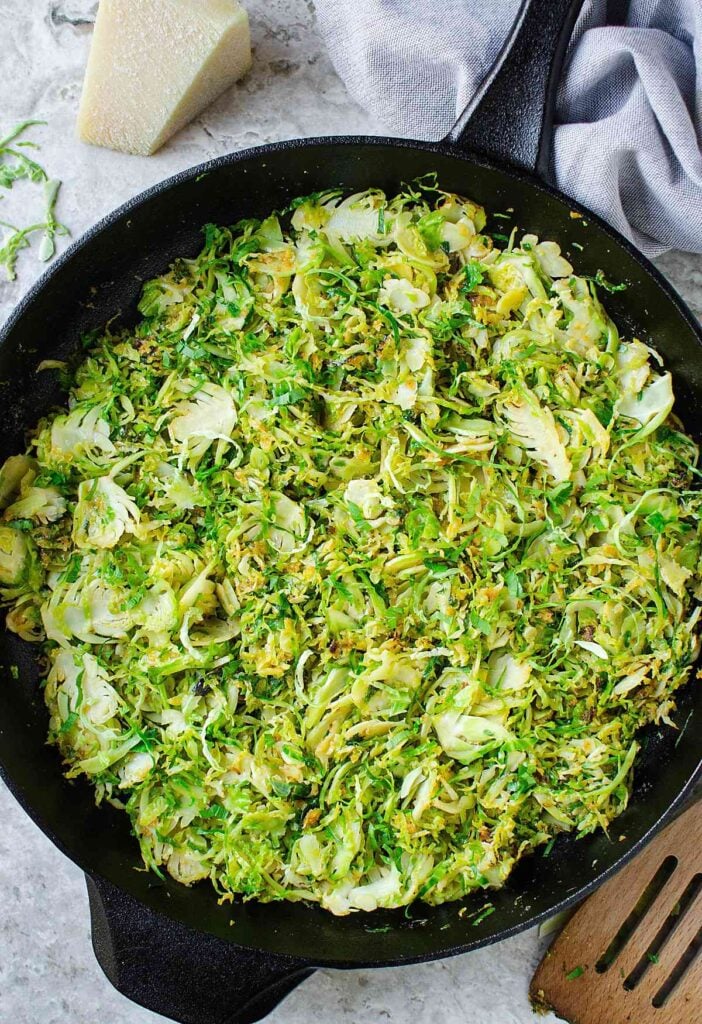 shredded and sautéed brussels sprouts in cast iron pan.