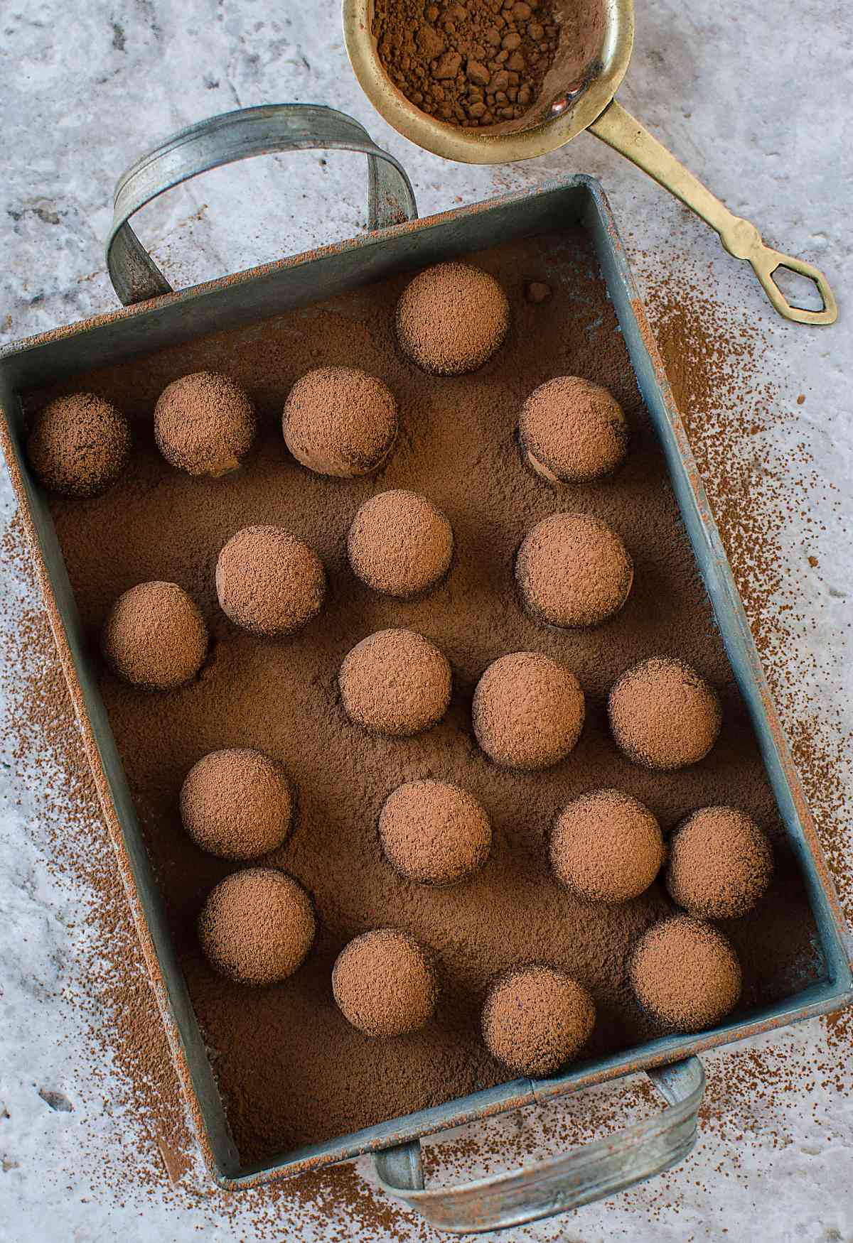 Dusting almond chocolate truffles with cocoa powder. | #truffles #chocolatetruffles #vegantruffles #almondtruffles