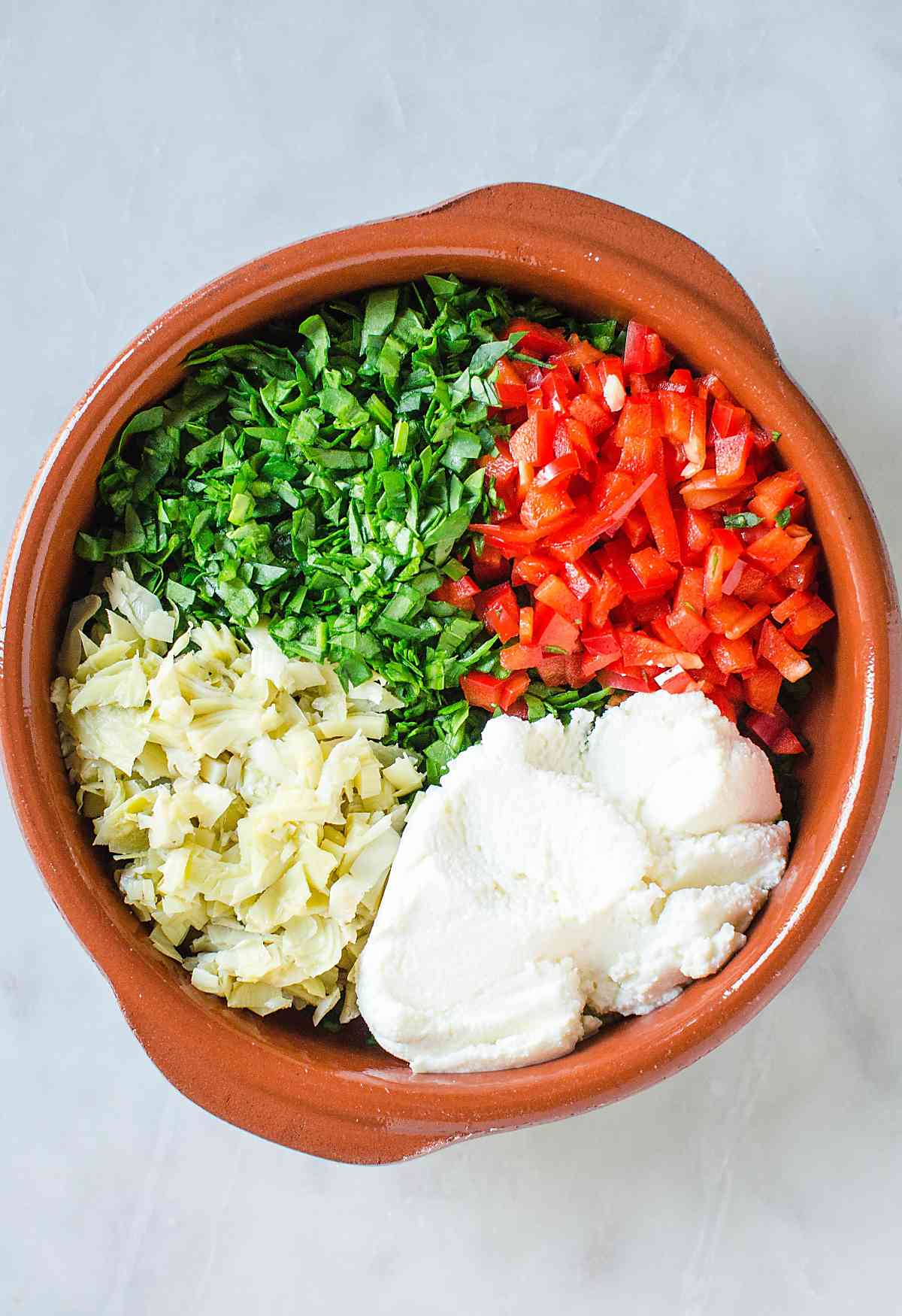 Preparing spread for artichoke spinach pinwheels