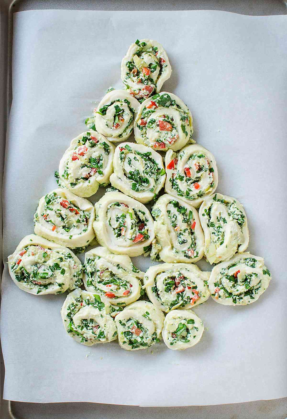 Arranging artichoke spinach pinwheels in a Christmas tree shape
