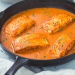 Ready to serve Indian salmon curry with coconut in cast iron skillet