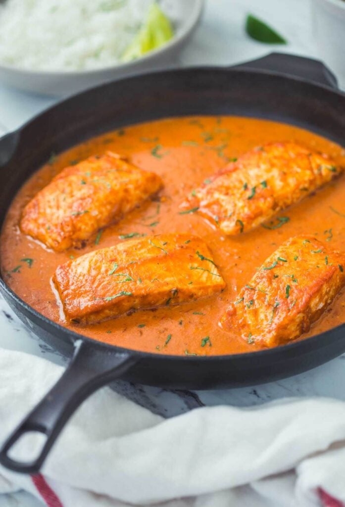 Ready to serve Indian salmon curry with coconut in cast iron skillet