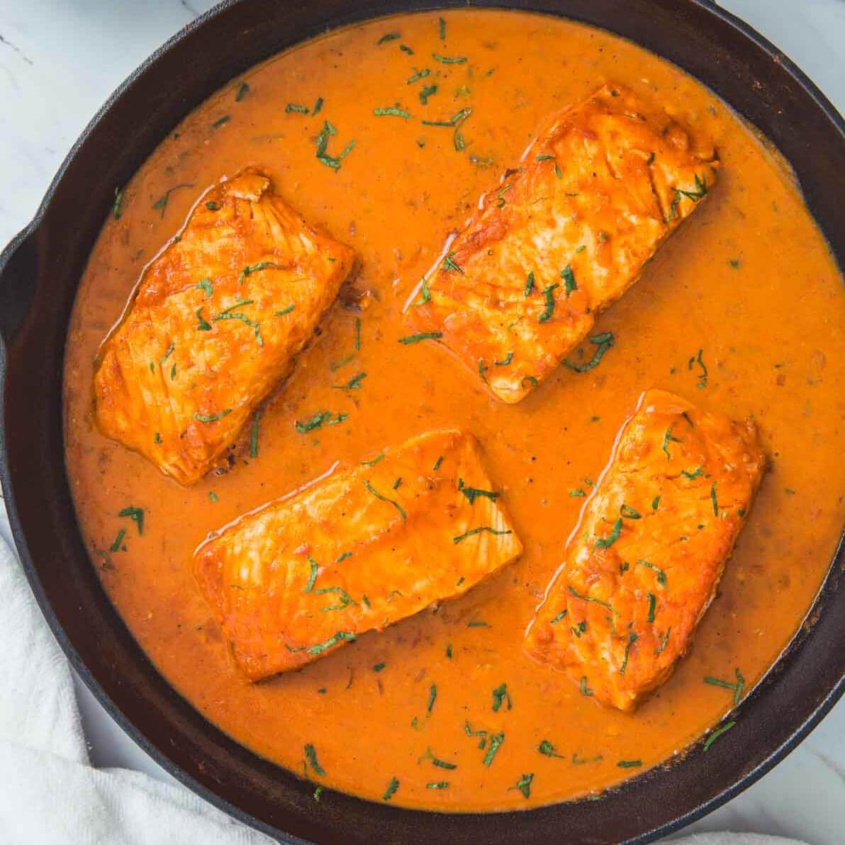 Ready to serve Indian salmon curry with coconut in cast iron skillet