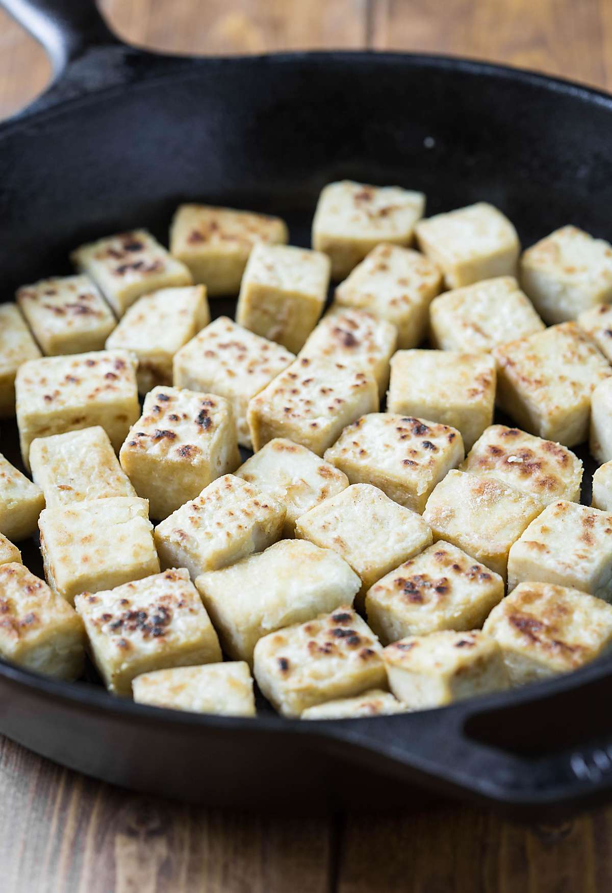 Cooking tofu in a cast iron skillet to form a crust.