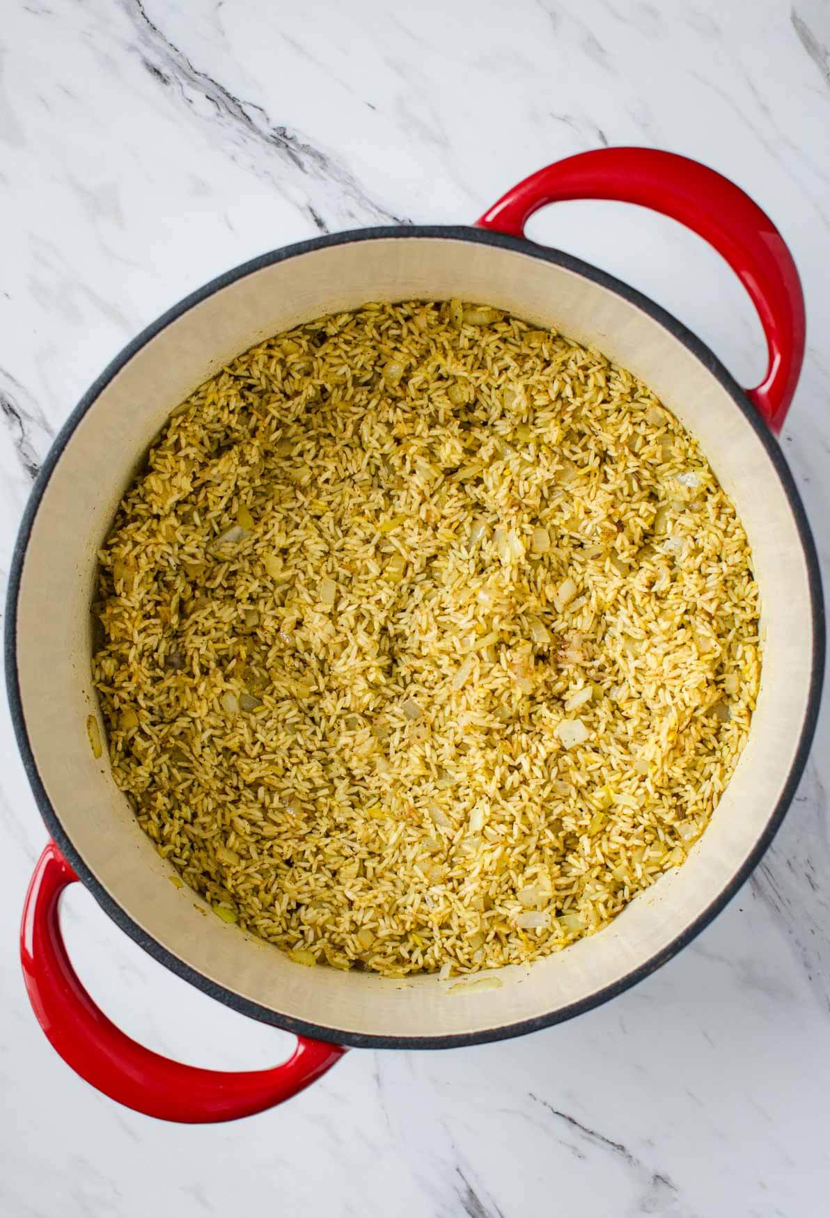 Sauteing rice with spices in the process of making palak paneer rice