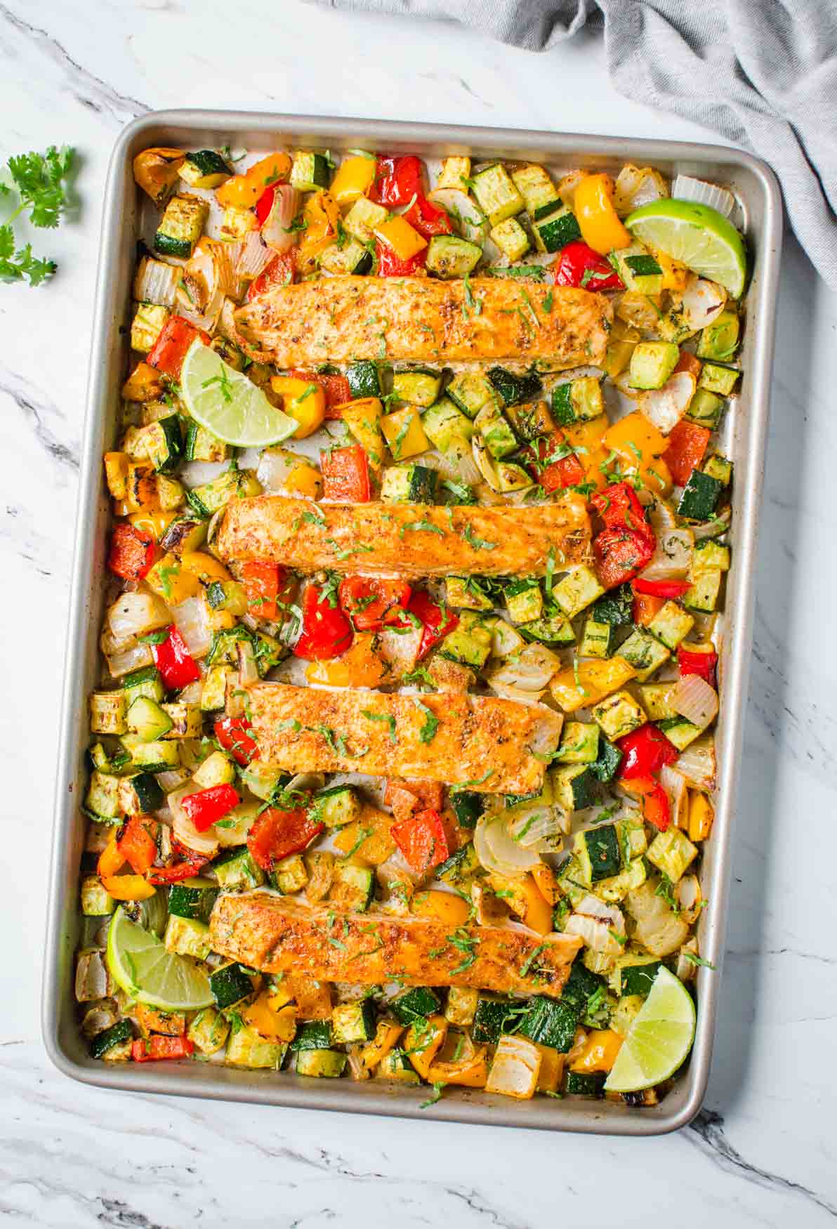 Salmon and vegetables baked together in one pan for an easy, healthy and quick dinner. Get the grilled look on veggies and salmon in the oven. And for a gluten-free meal serve with brown rice or quinoa. | #watchwhatueat #salmon #onepan #healthydinner #healthyrecipes