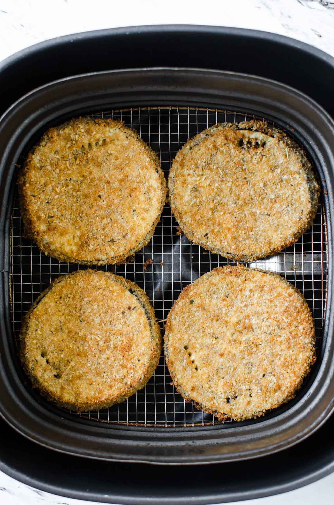 Healthy & easy Eggplant Parmesan fried in Air Fryer for the perfect crispy crust that exactly mimics the deep fried texture. Learn tips for perfect & mess free coating the eggplant slices with breadcrumbs. | #watchwhatueat #healthyrecipes #eggplant #eggplantparmesan #airfryer