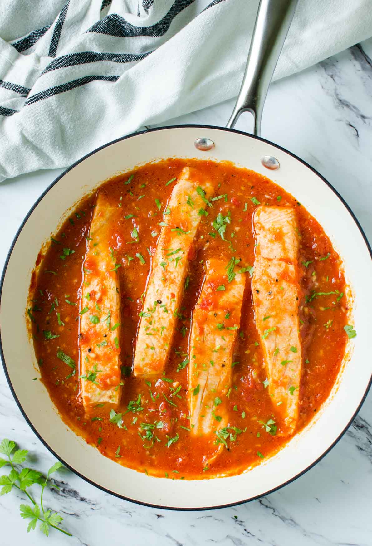 Salmon in Tomato Sauce - cook salmon in fresh garlic and tomato sauce. Serve on the side of pasta, grits or rice for complete healthy dinner or lunch. Quick and easy weeknight meal.