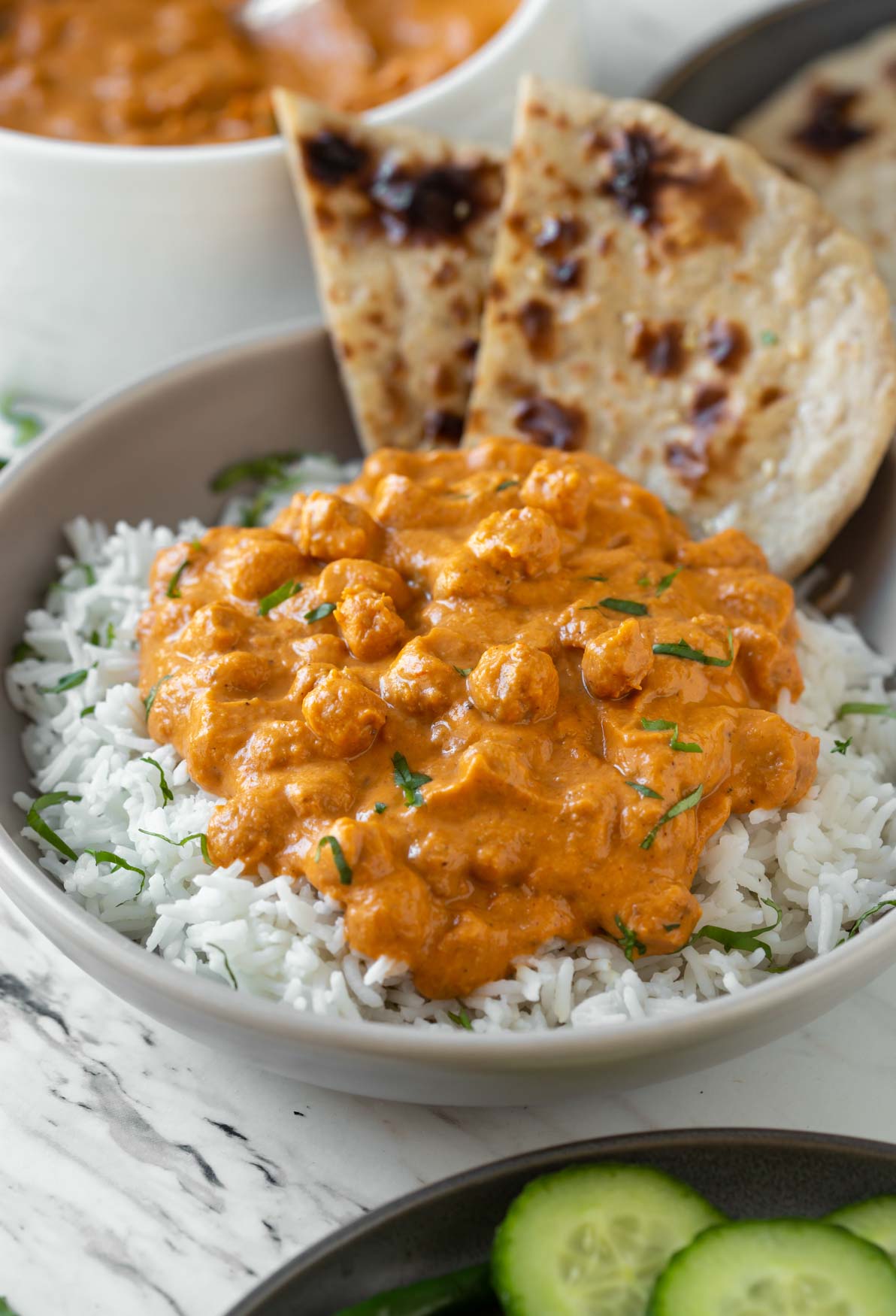 Vegetarian chickpea tikka masala served over a bed of white rice and with whole wheat naan on the side.