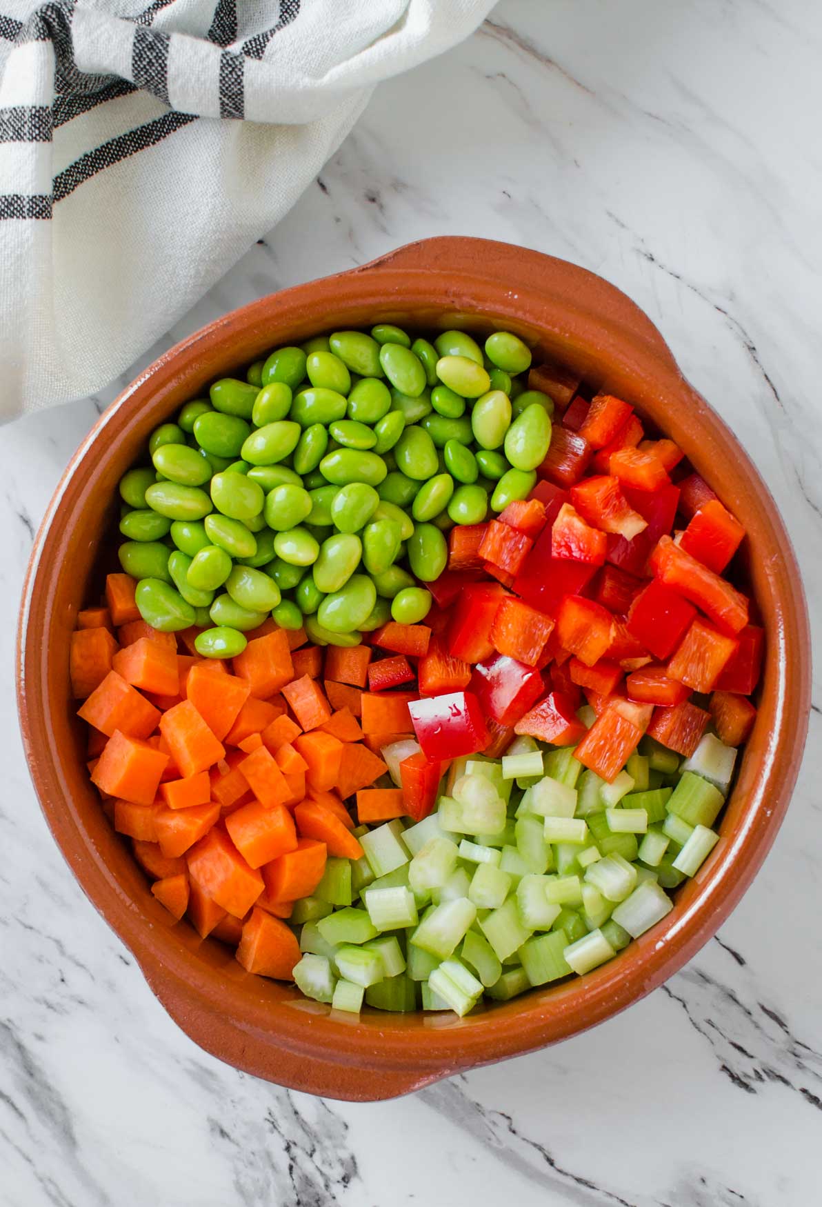 Fresh vegetables and beans in bowl for making Vegetable Barley Soup. 