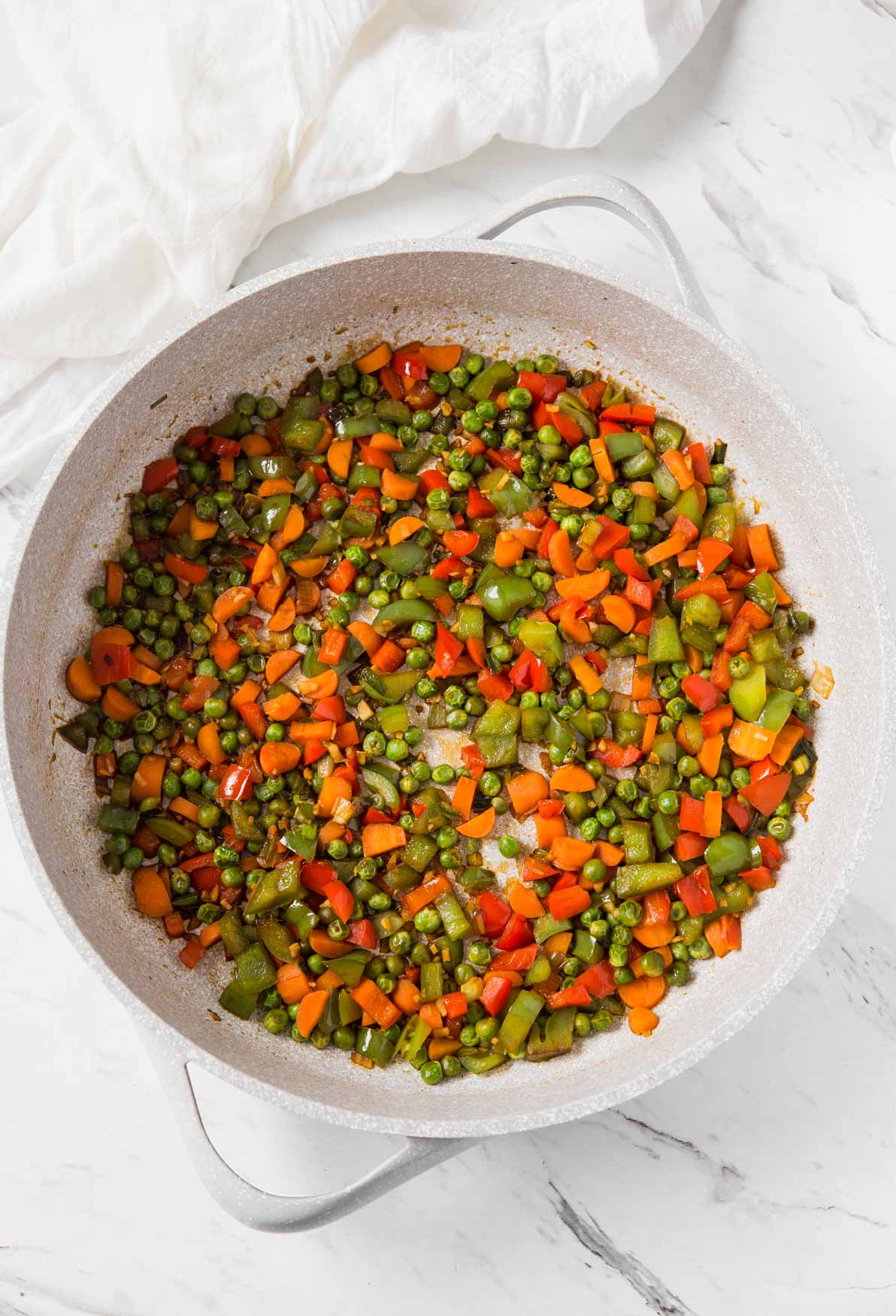 Stir-fried fresh vegetables in a large skillet for making vegetable healthy fried brown rice.