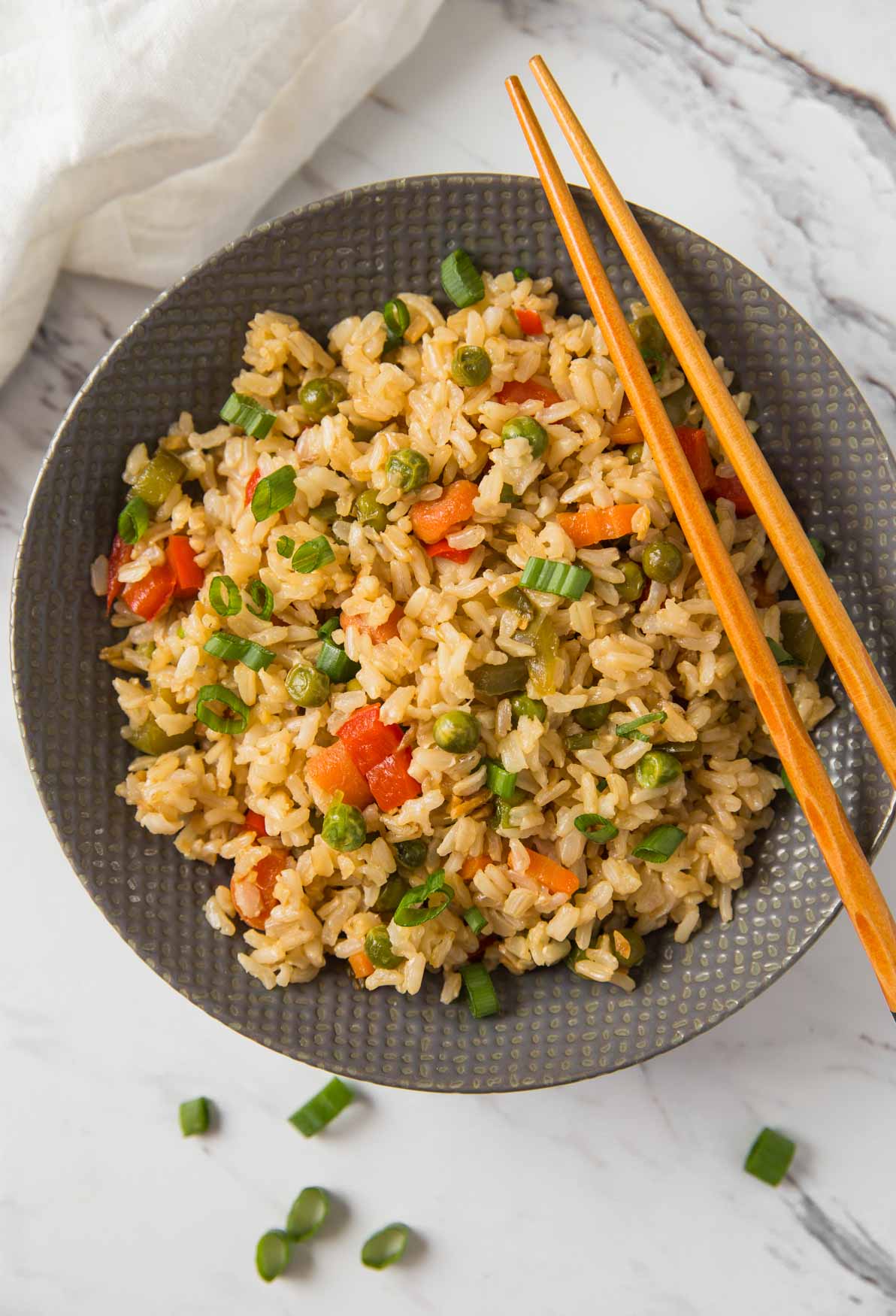 Healthy fried rice in a serving bowl with wooden chopsticks.