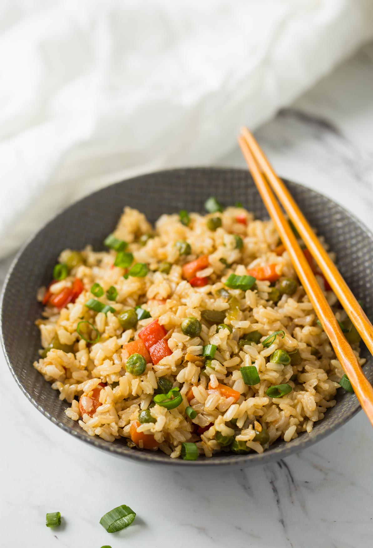 Healthy fried rice in a serving bowl with wooden chopsticks.