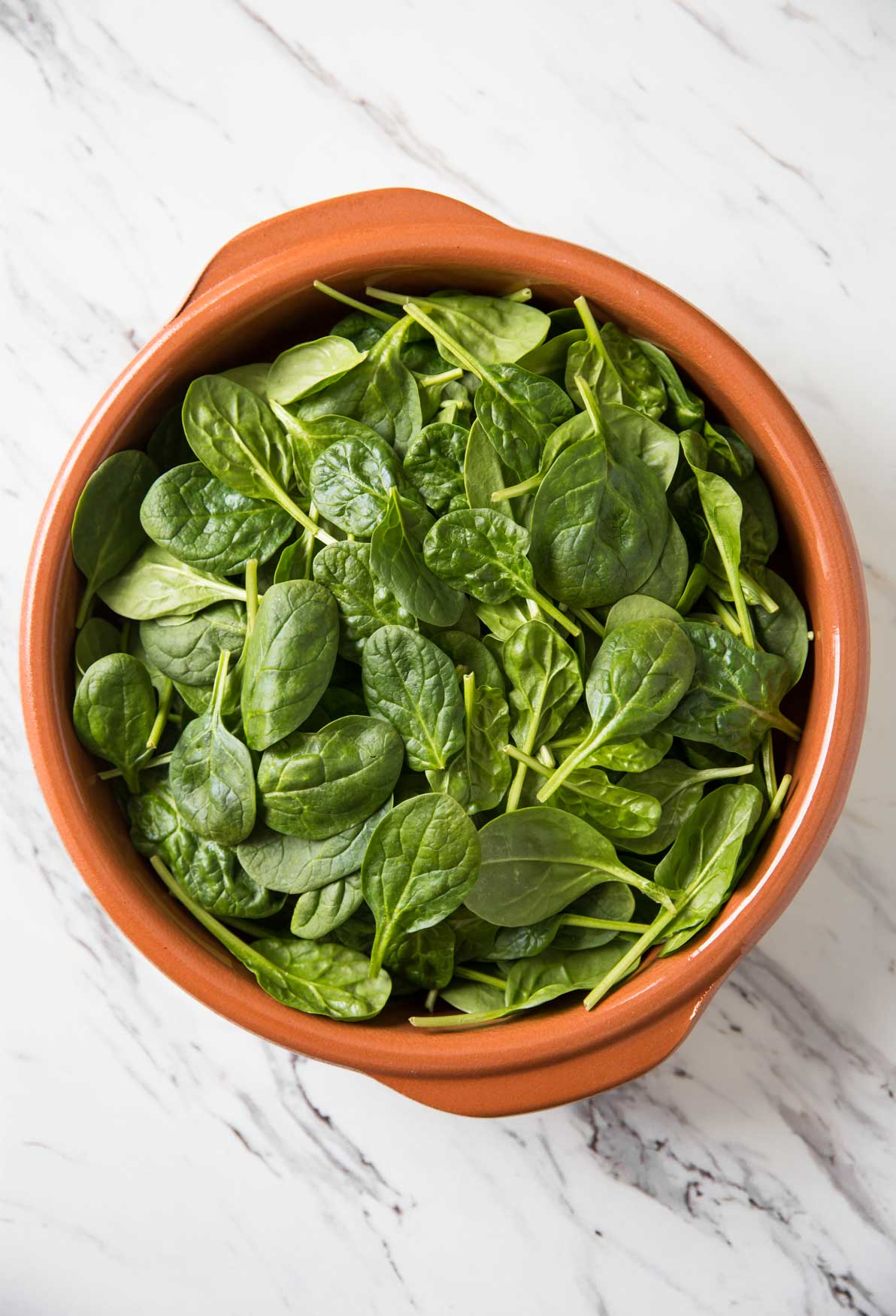 Fresh spinach in a terracotta dish for making palak paneer curry