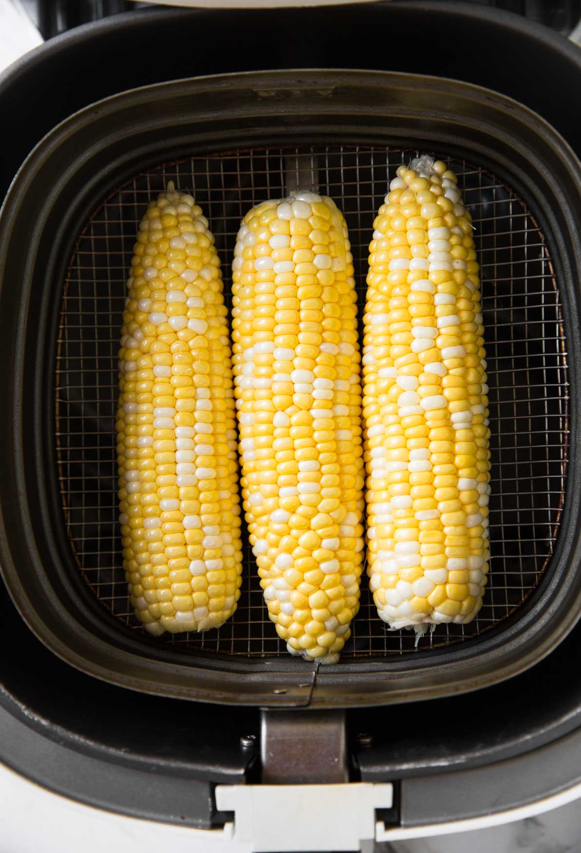 Corn on the cob placed in Air Fryer Basket.