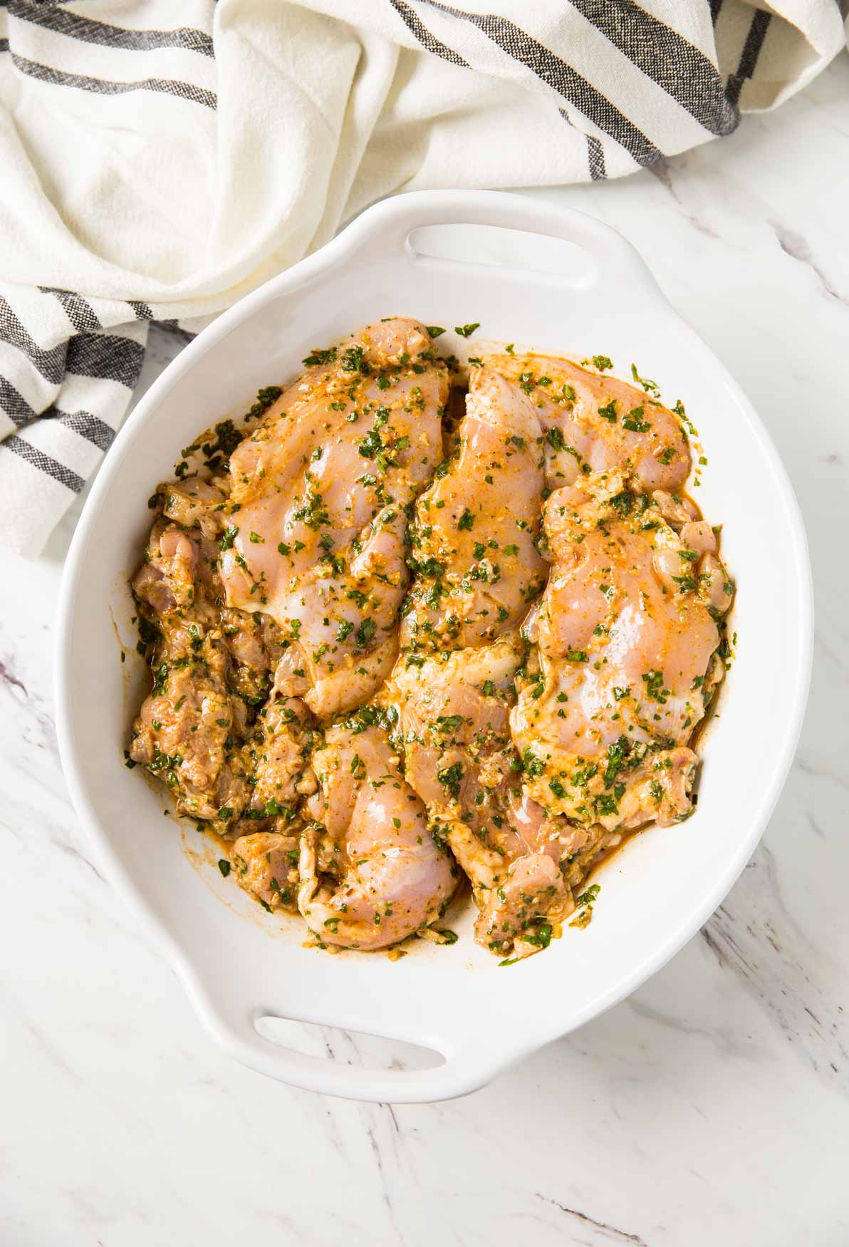 Cilantro lime marinated chicken in a large mixing bowl for making grilled chicken thighs.