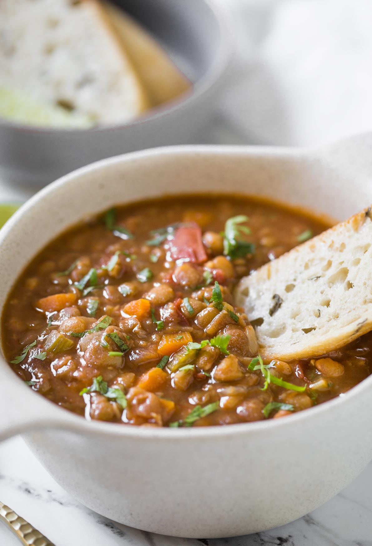 Whole lentil soup in bowl with bread