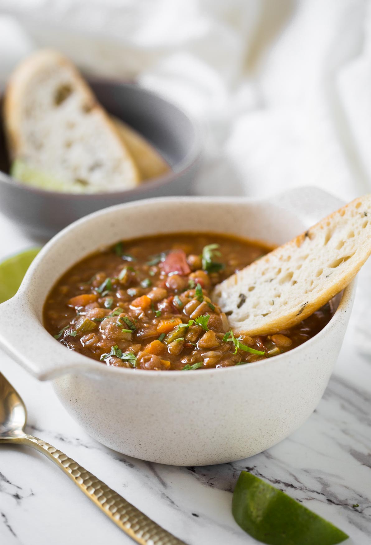 Whole lentil soup in bowl with bread