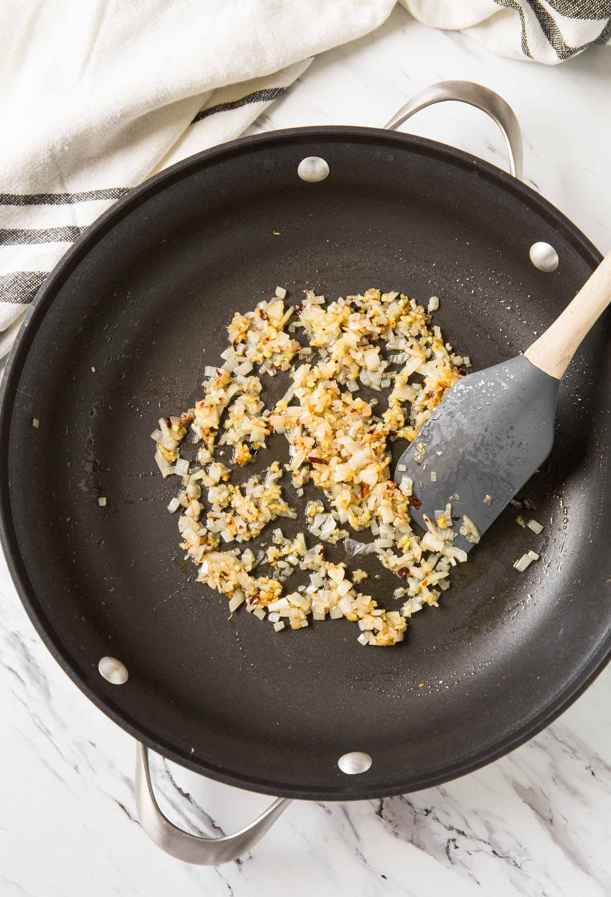 Sautéing garlic and onion in a large skillet.