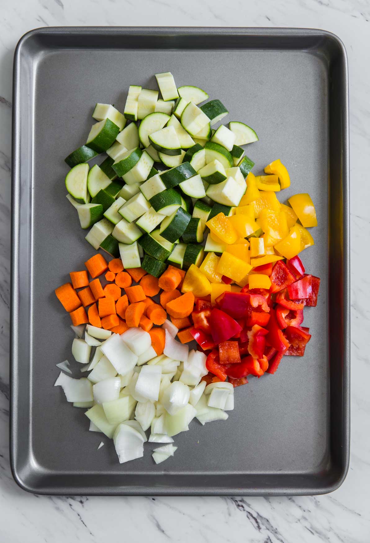 Vegetables cut into bite-size pieces in a baking pan
