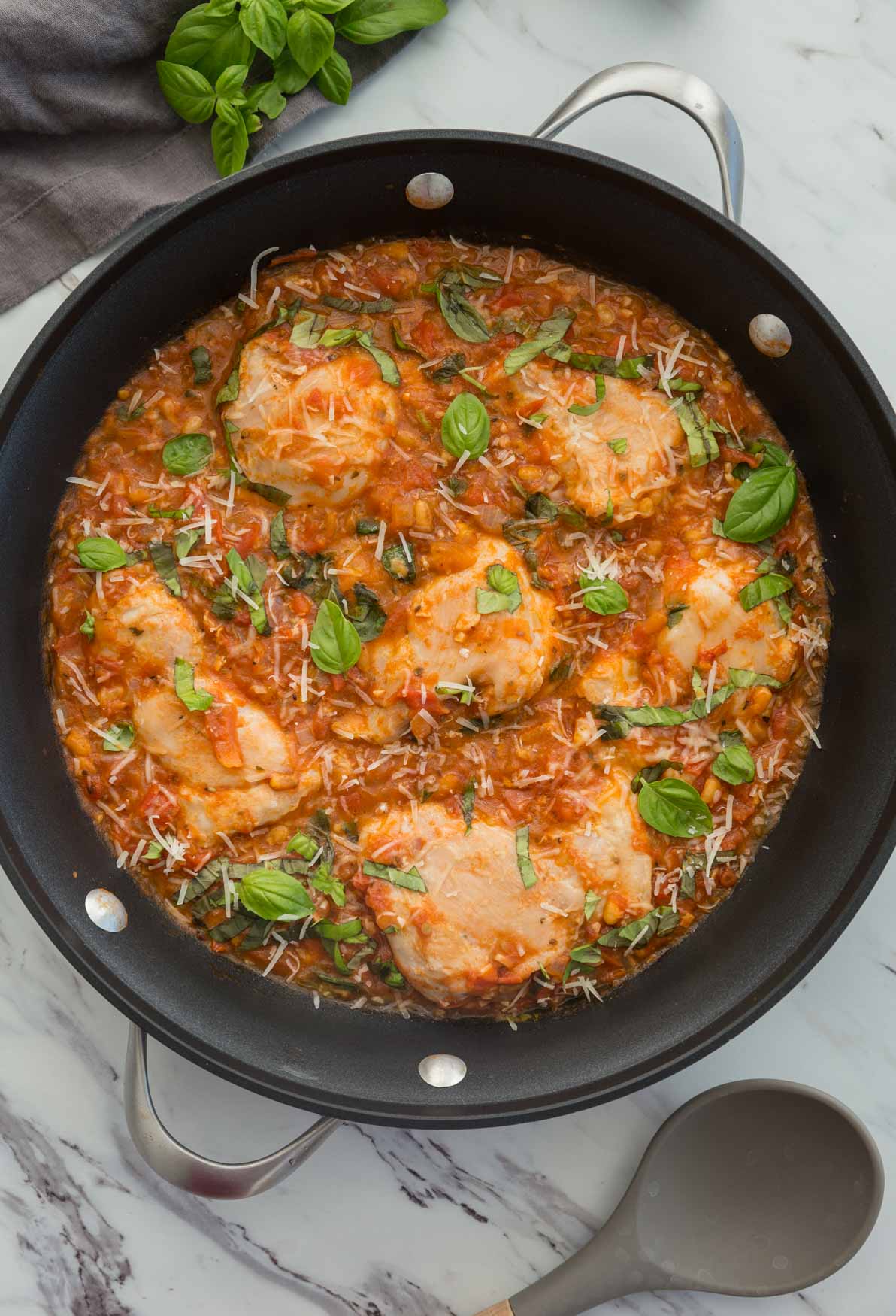Garlic basil chicken with tomato sauce in a large skillet.