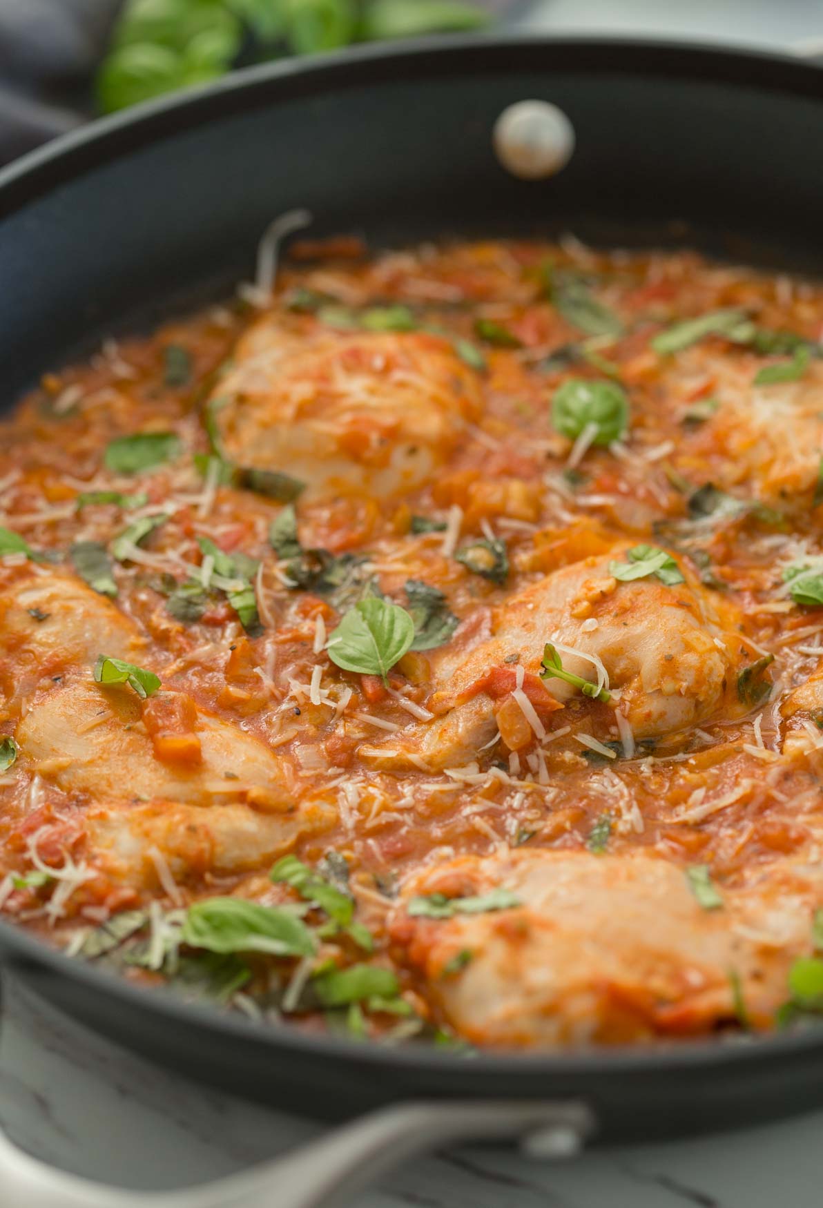 Chicken in garlic basil tomato sauce in a large skillet.