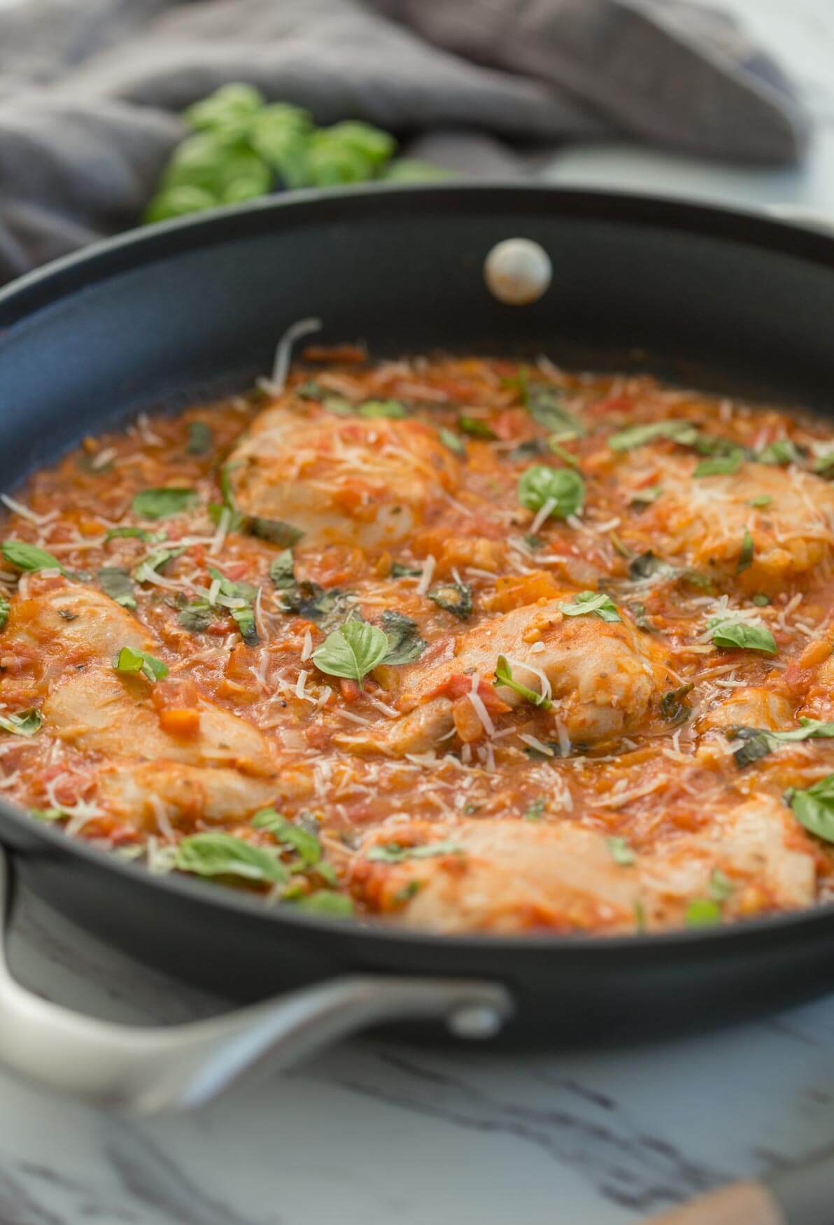 Garlic basil chicken with tomato sauce in a large skillet.