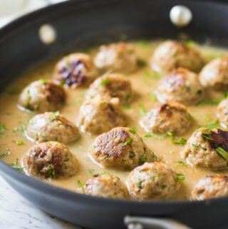 Healthy ground turkey meatballs with gravy in a large skillet