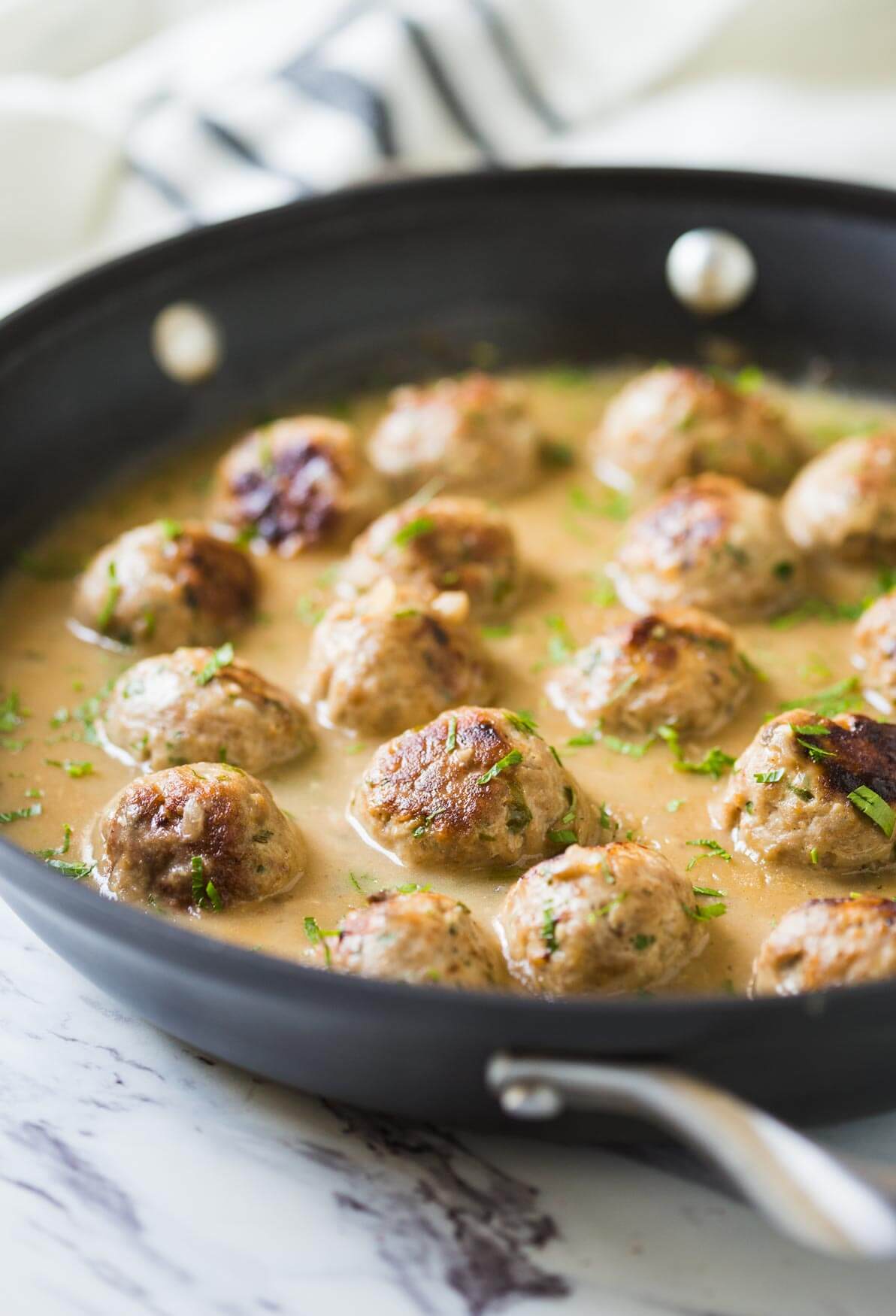 Healthy ground turkey meatballs with gravy in a large skillet