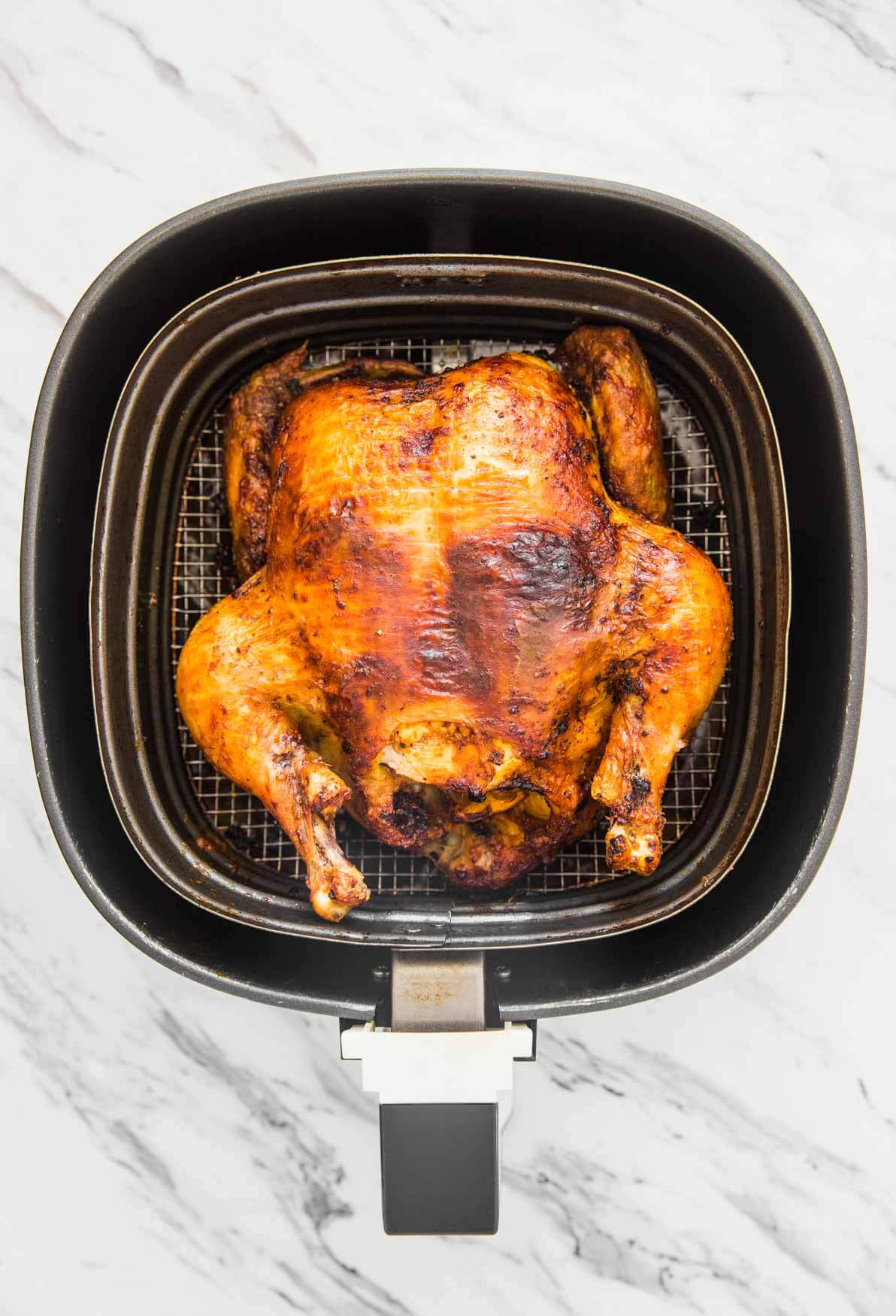 Roasted whole chicken in Air Fryer basket