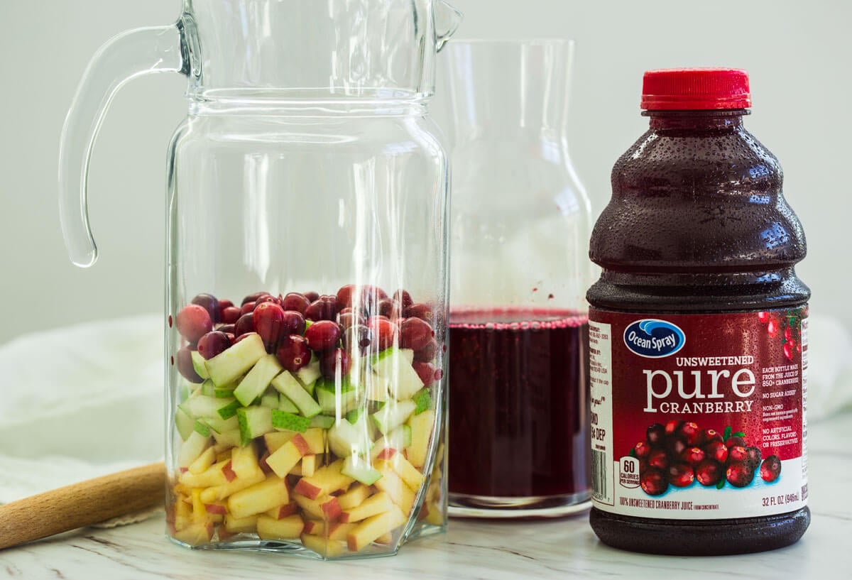 fresh diced fruits in a pitcher and fresh cranberry juice for making healthy cranberry sangria